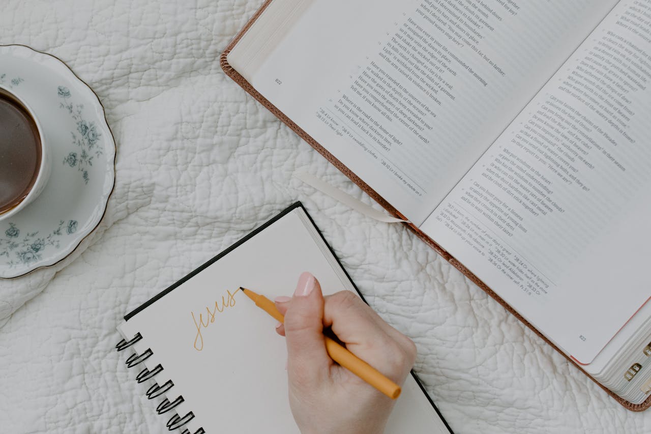 Person Writing on a Notebook