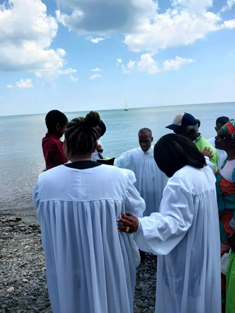 Baptism at the lake: New life in Christ, witnessed by the whole family.