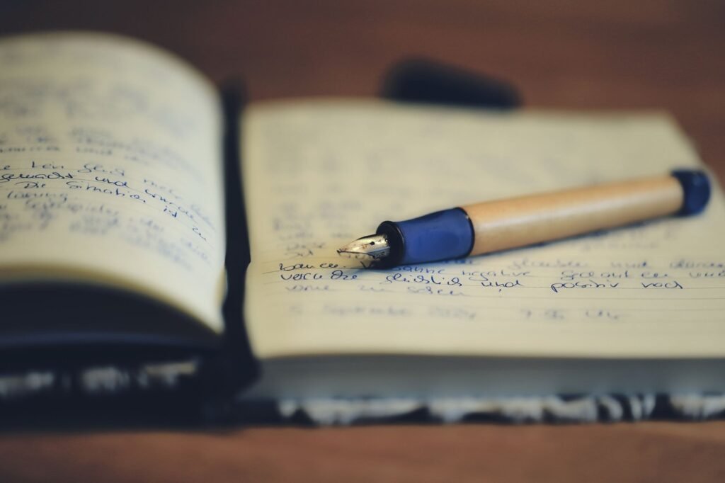 A handwritten journal lying open with a fountain pen resting on the page
