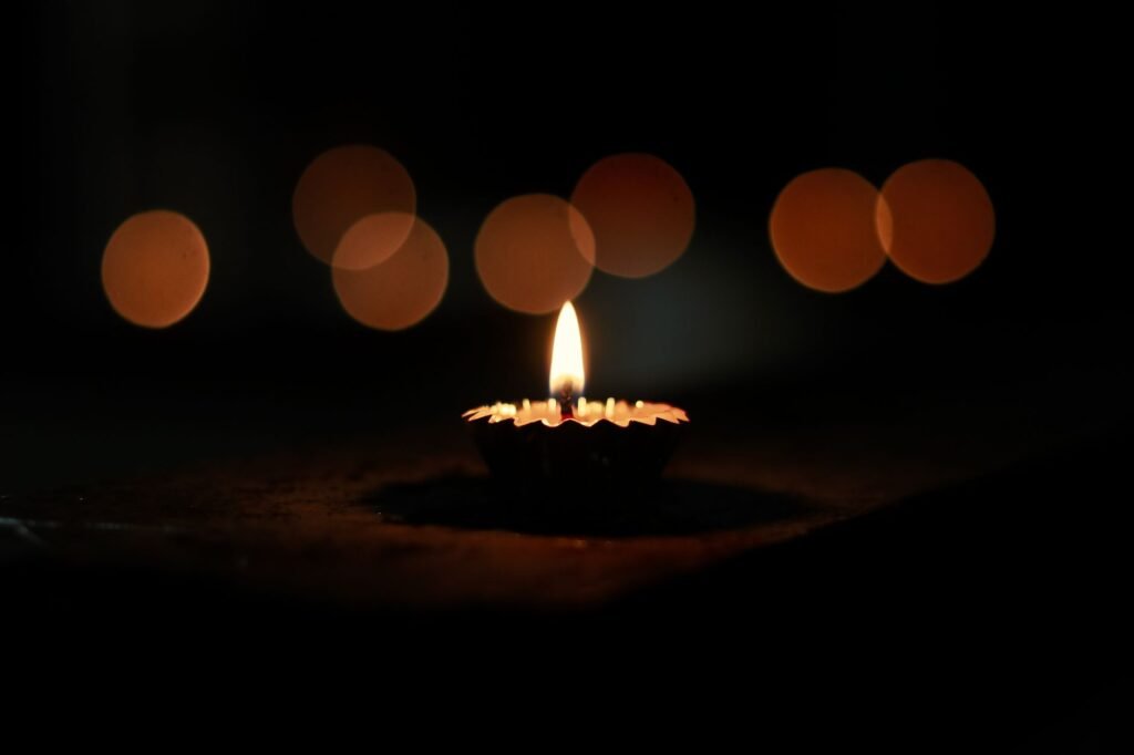 A single oil lamp flame glowing in the dark