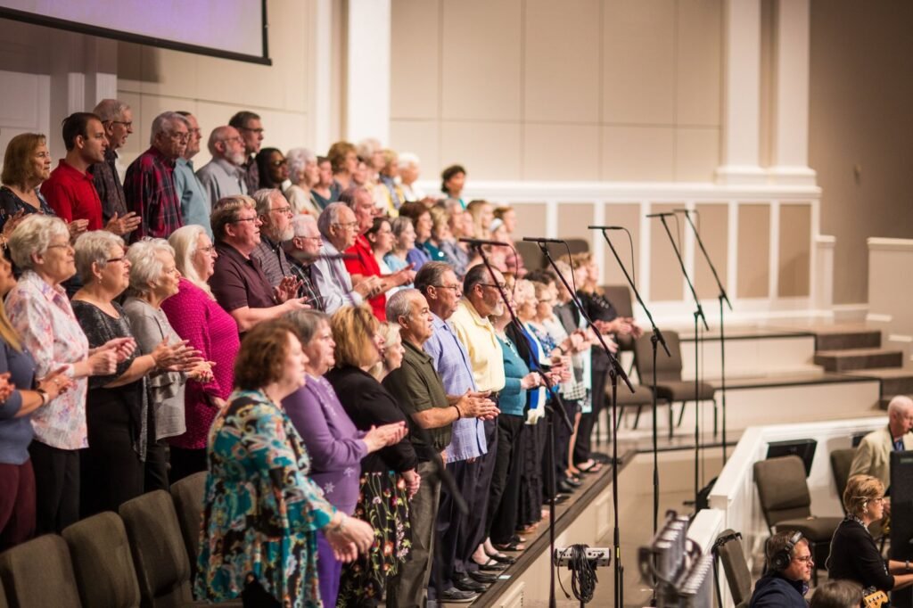 A congregation of all ages standing and singing together in a sanctuary
